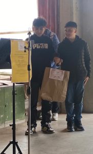 2 bambini con un sacchetto di carta in mano ritirano un premio